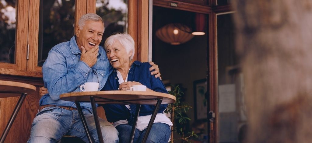 Senior couple enjoying coffee at an outdoor café in Whistler Village, perfect for relaxing after a day of exploring the mountains.