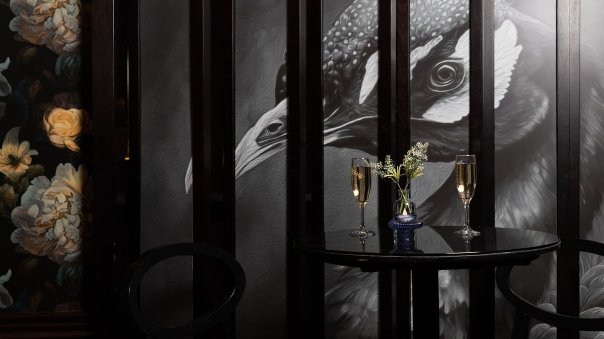 Two champagne glasses on a round table & vase in Minq Bar Lounge at Crown Hotels Perth