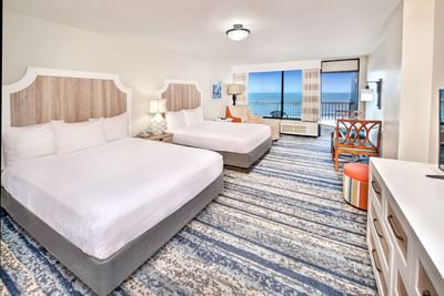 Ocean Front Kitchenette with two beds, chairs, dresser, and balcony with ocean view at the Daytona Bahama House Hotel