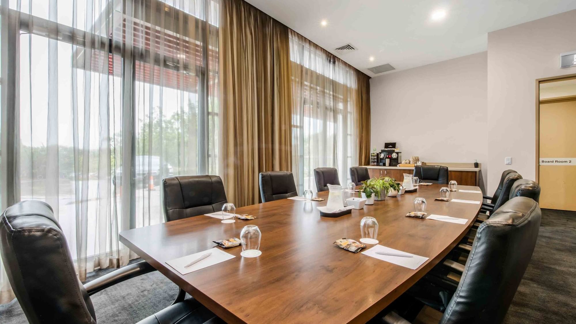 Boardroom One with a long table, black chairs, and abstract art on the wall at Mercure Kooindah Waters