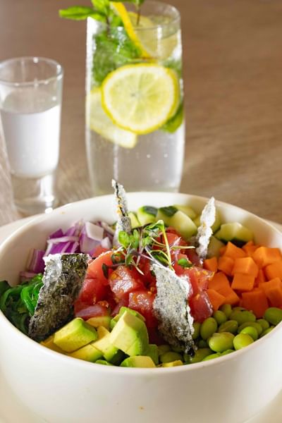 Bowl of vegetable salad with tuna and two glasses of drinks at Ellipse Grace Bay