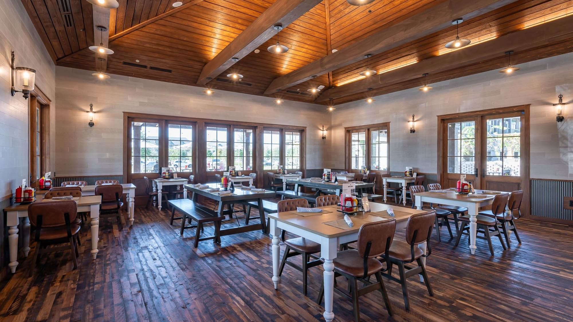 Illuminated interior with dining tables in Bark ‘N Brine at Camp Creek Inn
