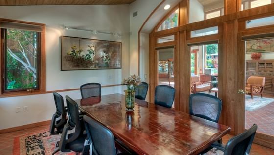 wooden conference table with black chairs