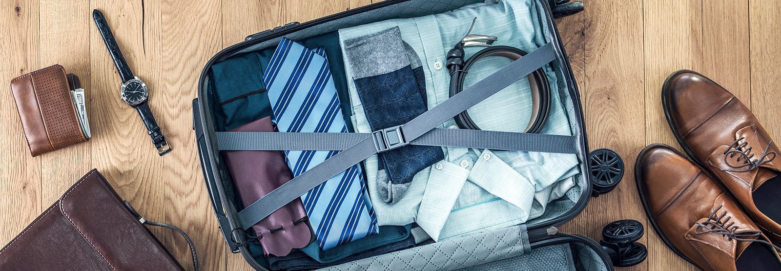 A neatly packed travel bag with business attire at Grove Hotel