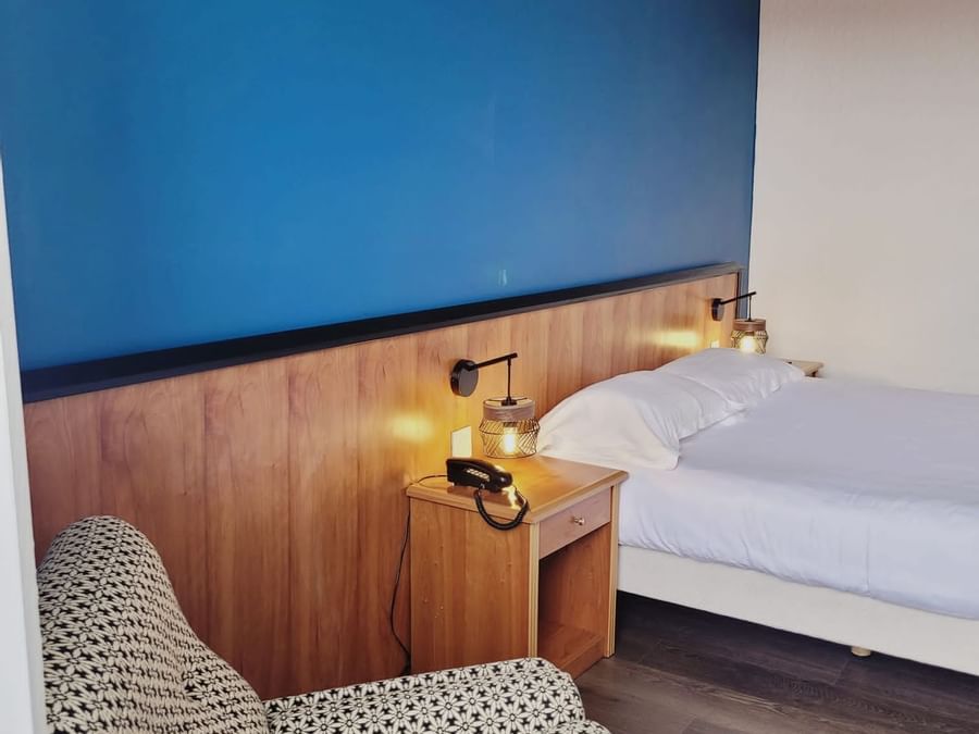 Comfy double bed with lamps in a room at The Originals Hotels