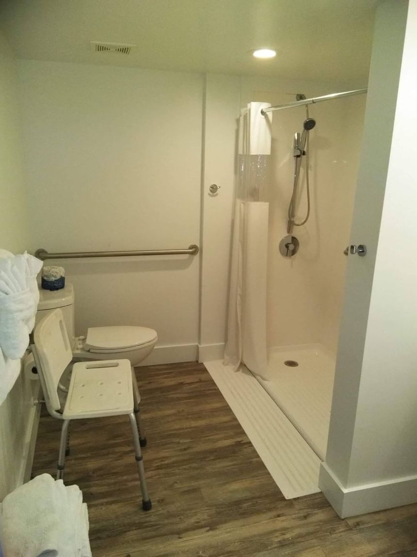 Well-appointed bathroom with roll-in shower & a shower chair at Bayside Inn Key Largo