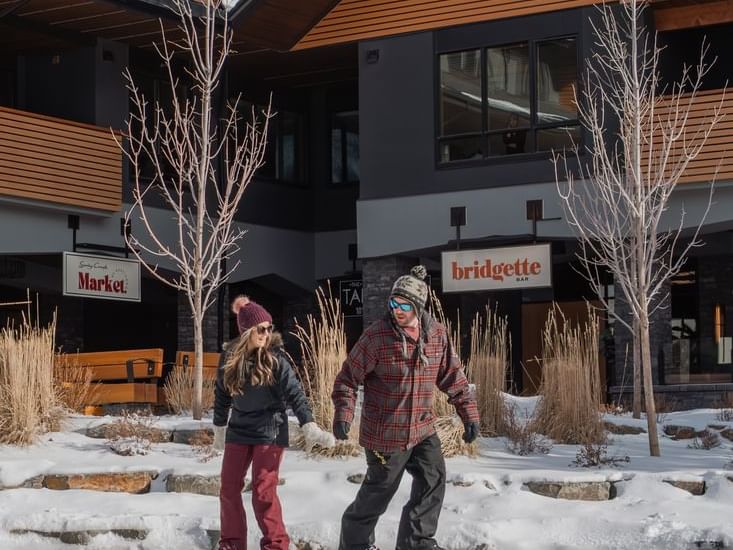 Two people ice skating in front of Spring Creek Vacations Condo at night, all-inclusive resorts in Canmore