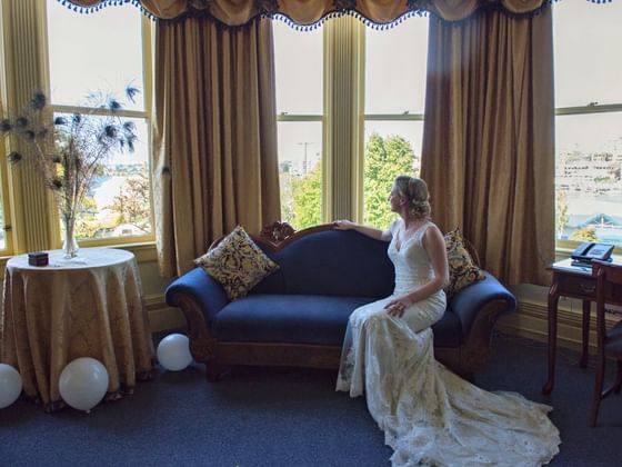 Bride overlooking the view from a window lounge at Huntingdon Manor