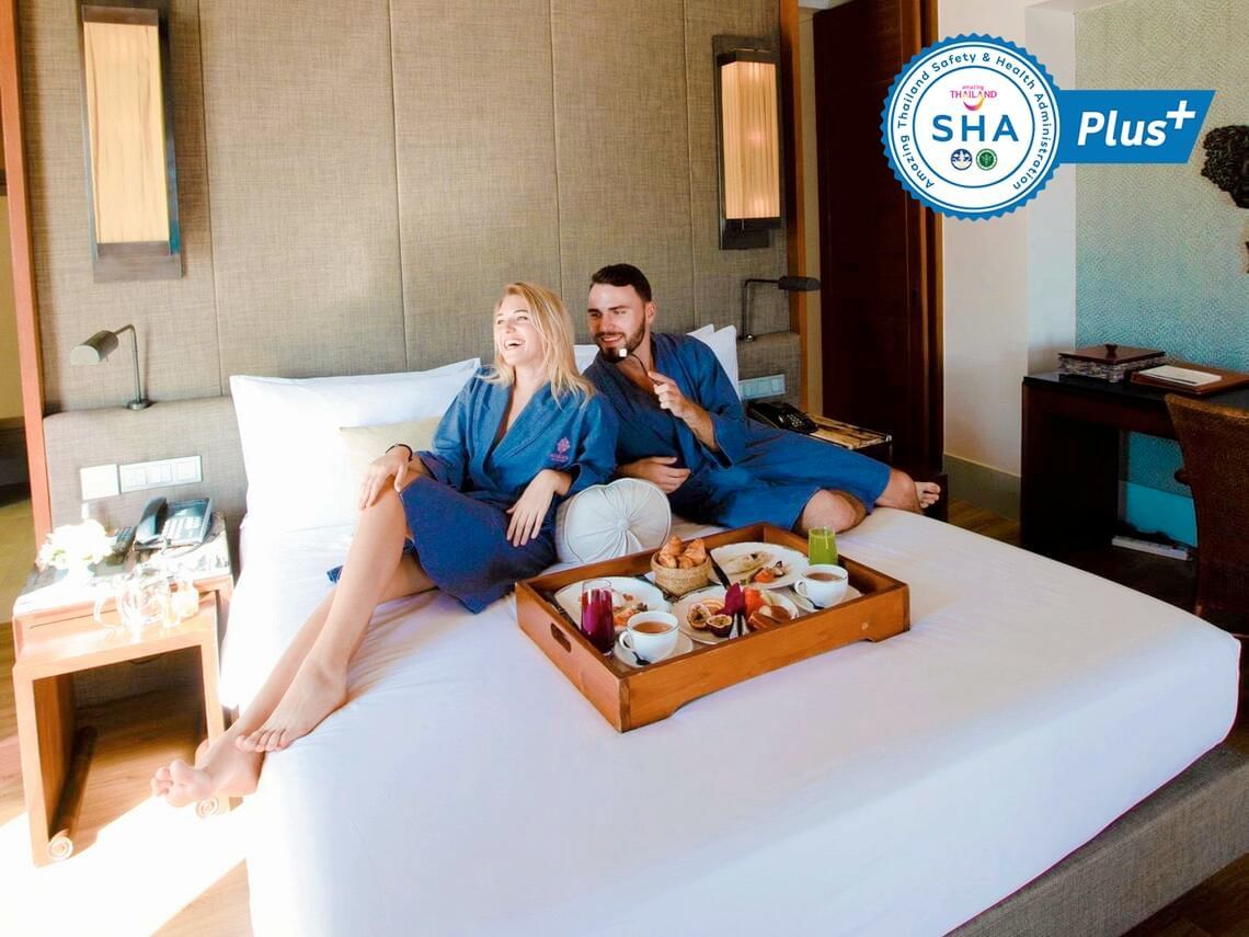 Happy couple enjoying in room dining at Amatara Wellness Resort