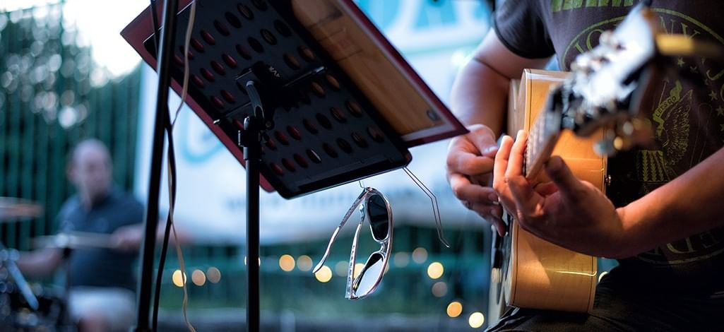 a guitar player performing in an outdoor concert