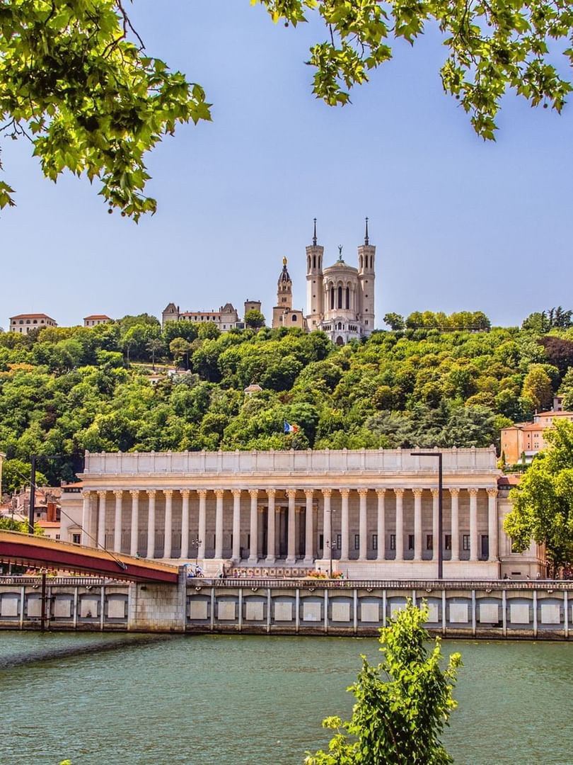Scenic city view with the Saône River and the grand Palais de Justice under bright skies near Warwick Reine Astrid - Lyon