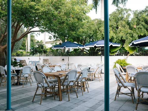 Outdoor restaurant seating area with open navy blue umbrellas