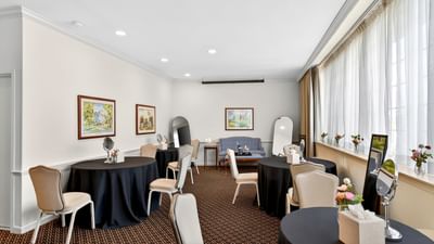Dressing room featuring black covered round tables with vanity mirrors and a small sofa at Avon Old Farms Hotel