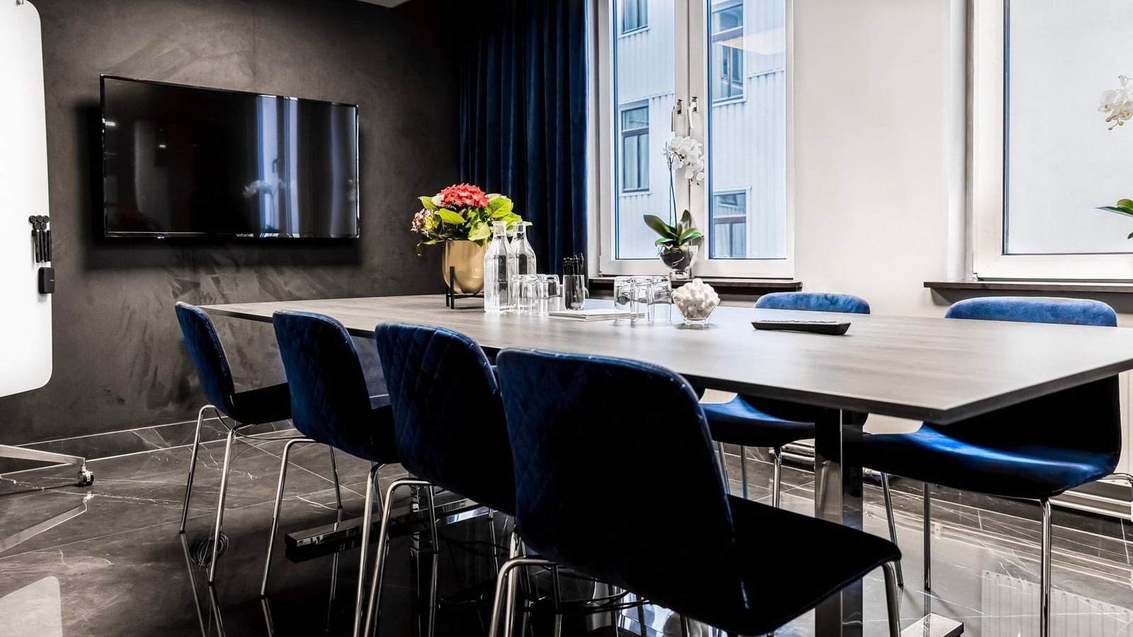 Modernt mötesrum på Hotel Riverton i centrala Göteborg med marmorgolv, konferensbord, stolar och skärm för presentationer