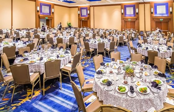 large banquet hall with many circular tables set