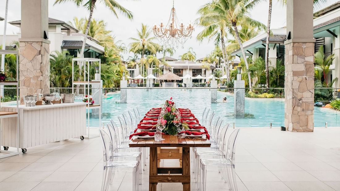 Outdoor wedding set up with long dining table by the pool in Lagoon View Terrace at Pullman Port Douglas