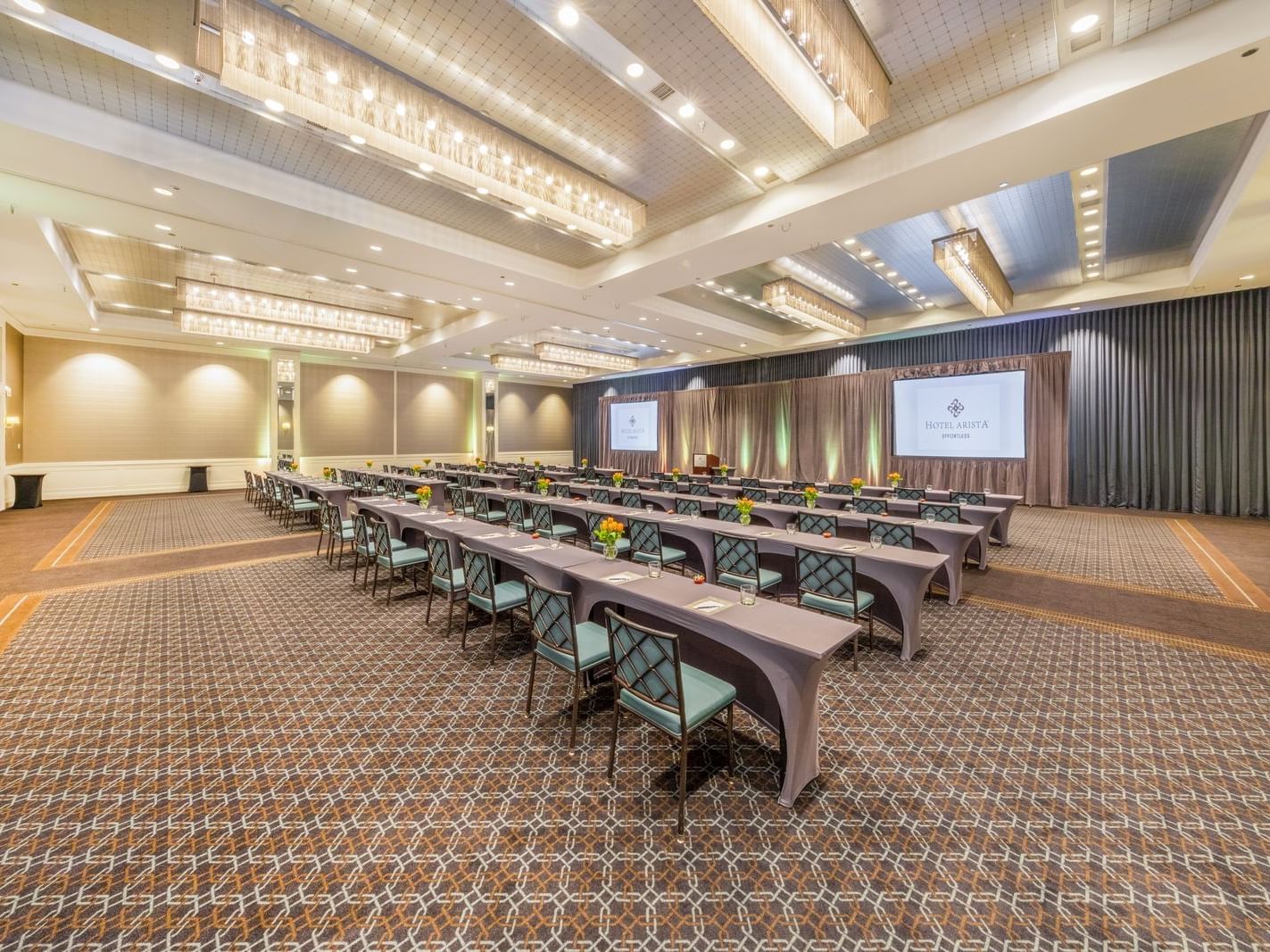 rows of long tables and chairs in a ballroom