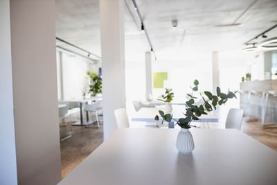Bistro & Pizzeria with vases on white tables and minimalist decor at Avaneo Hotel, one of the hotels in Marktredwitz