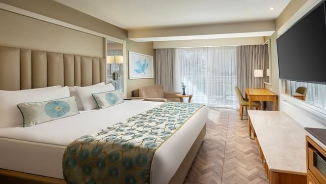 Titanic Deluxe Lara’da geniş yataklı, Titanic Deluxe Lara – Anex Standard Garden odasında, geniş yataklı, koltuklu ve büyük televizyonlu lüks bir konaklama alanı.ve büyük televizyonlu lüks bir odası.