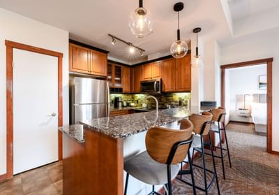 Modern kitchenette area with wooden cabinetry and high stools in Two Bedroom Suite at Blackstone Mountain Lodge