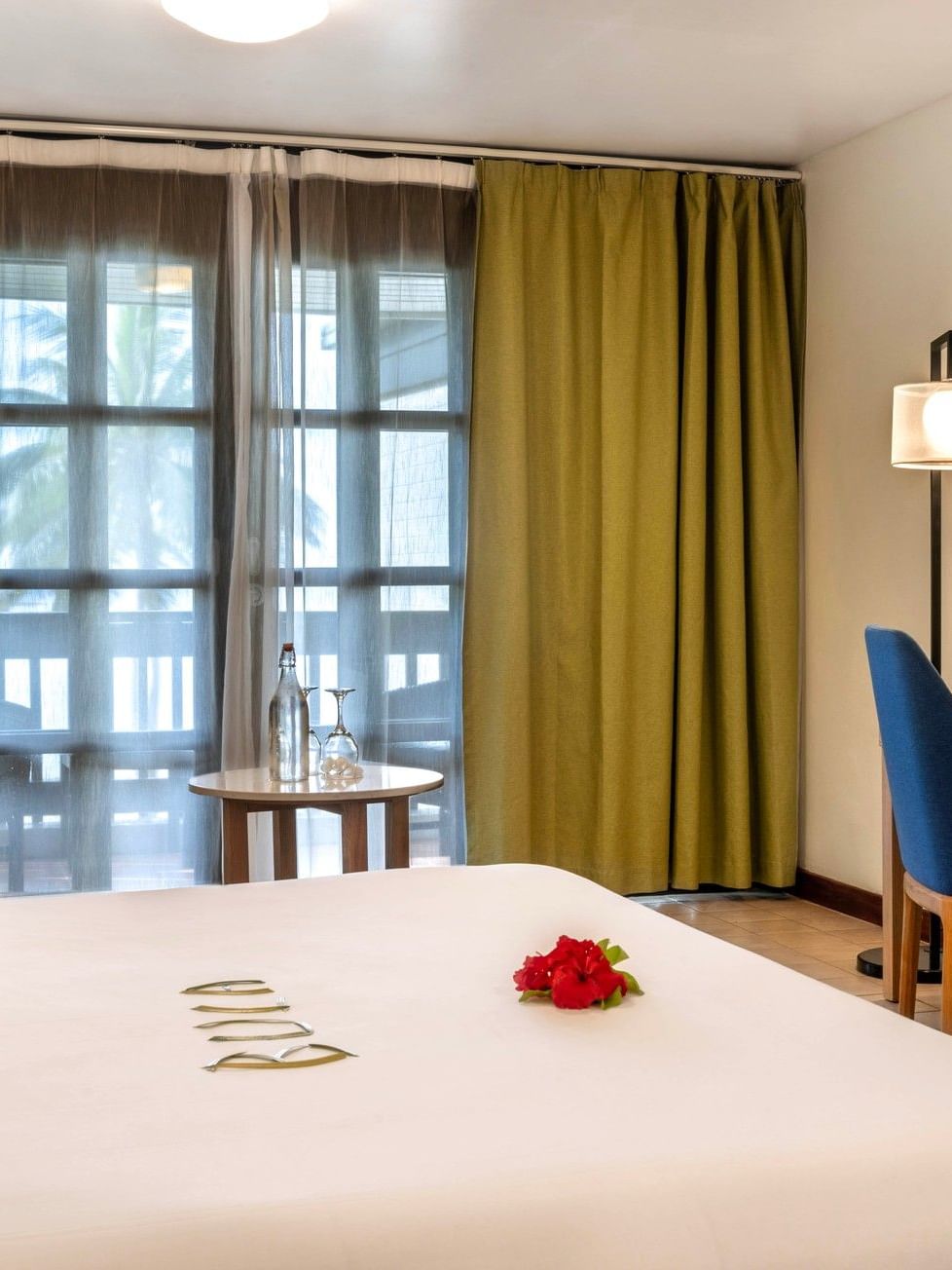 Suite with bed, desk, chair, and balcony at The Naviti Resort in Korolevu.