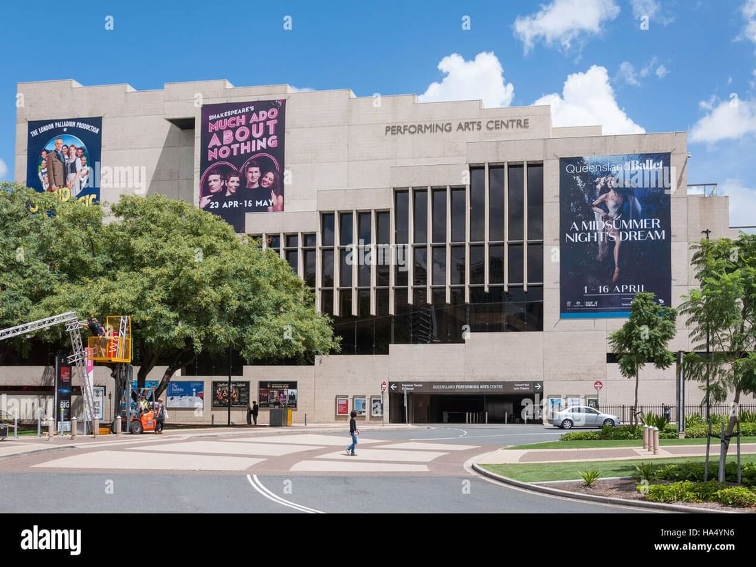 Exterior of the Queensland Performing Arts Centre building with large show banners under a blue sky near The Sebel Brisbane