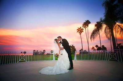 Newlyweds kissing under sunset Tampa Bay.