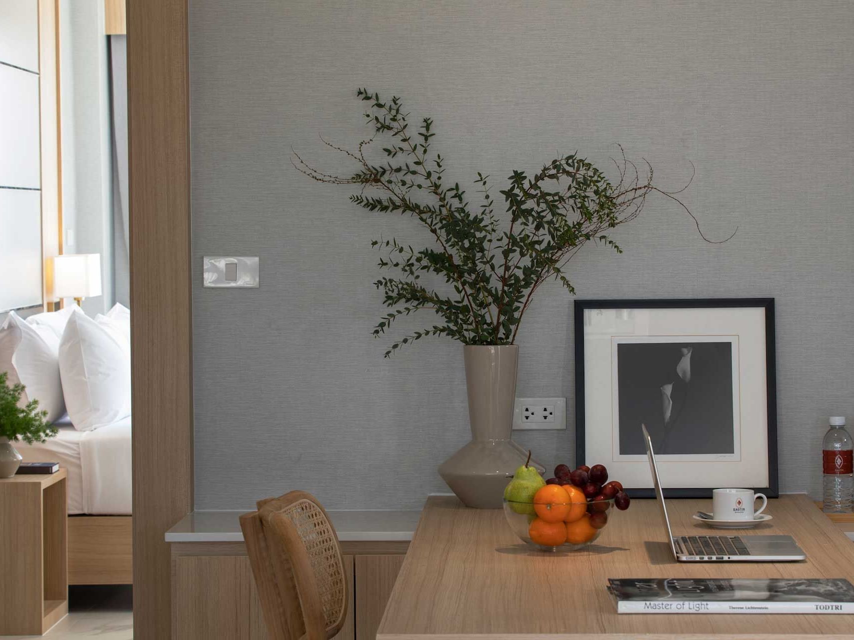 Laptop, fruit bowl & cup of tea on work desk in Luxury Suite Seaview at Eastin Resort Rayong