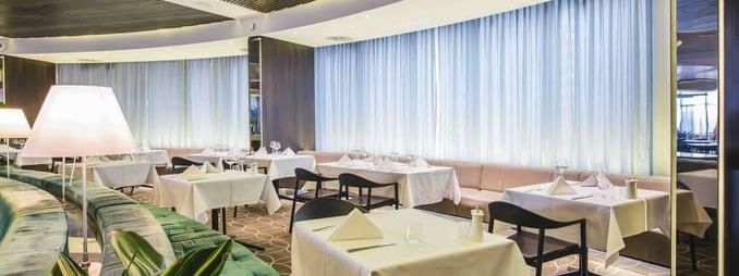 Stylish 33Grill Bar & Dining interior at Novotel Sydney with elegantly set tables and soft green seating