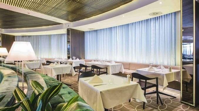 Stylish 33Grill Bar & Dining interior at Novotel Sydney with elegantly set tables and soft green seating