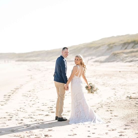 Bridal Couple taking photos in the beach near Pullman Magenta Shores