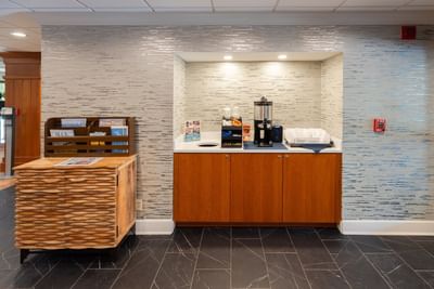 Coffee and snack station by the paper rack in the lobby at The Boulevard Inn & Bistro