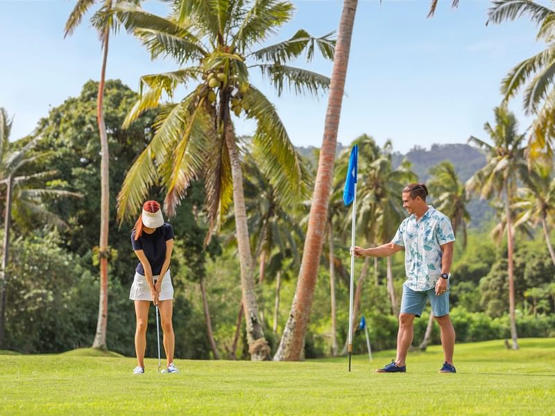 A Couple playing golf in a Golf Course at The Naviti Resort - Fiji
