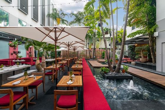 Outdoor dining area by a pond at South Beach Hotel