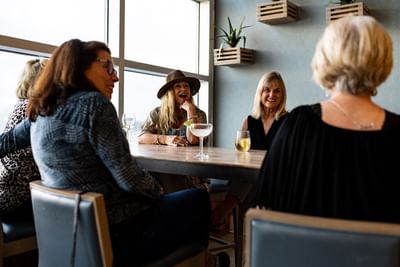 Group of women sharing cocktails and conversation in Lost Key Bar at Margaritaville Resort Biloxi