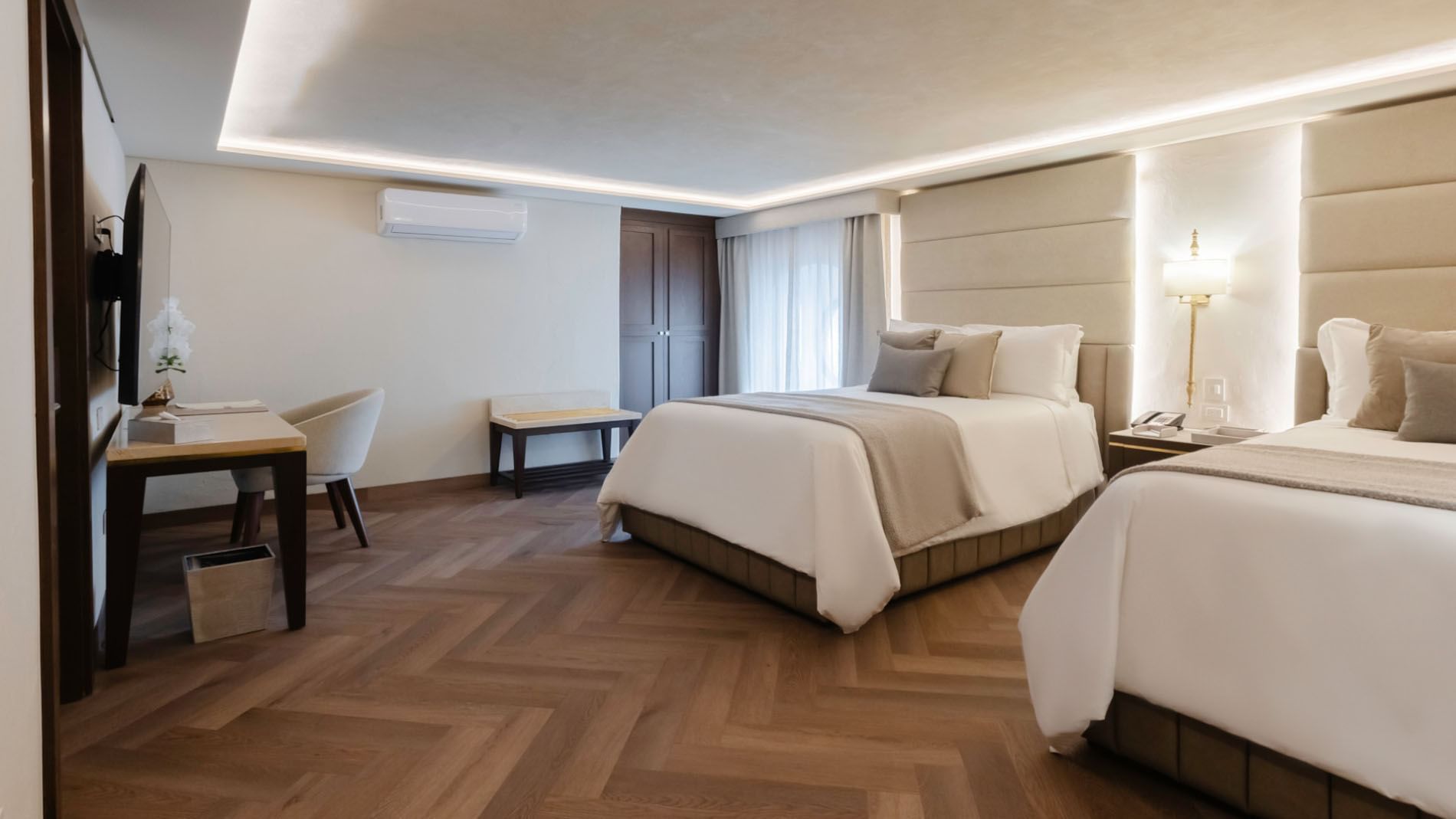 Two Double Deluxe with two beds, wood-patterned floors, and a dark wood closet in the back at Quinta Real Puebla