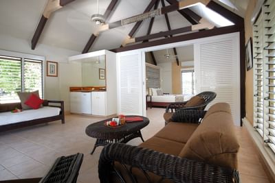 Open-plan living space with high ceilings, and wicker furniture in Lagoon Bures at Musket Cove Island Resort & Marina