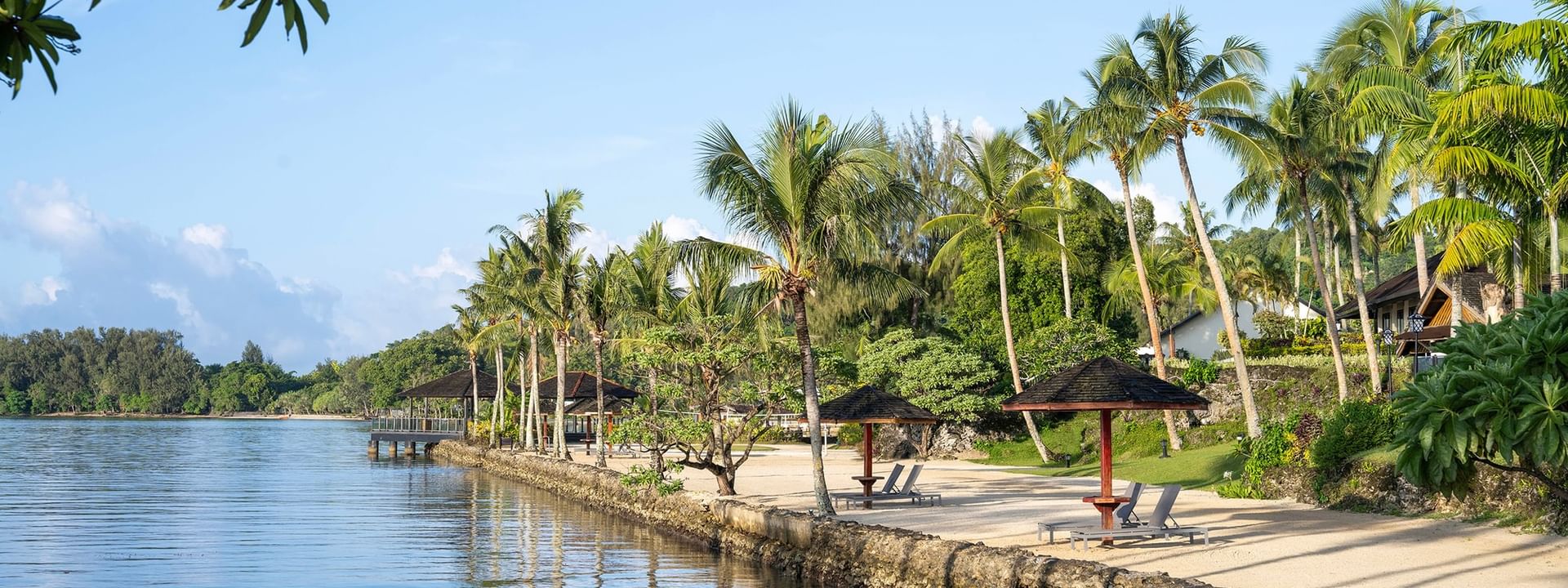 Beachside relaxation area with lounge chairs and umbrellas at Warwick Le Lagon - Vanuatu, Efate