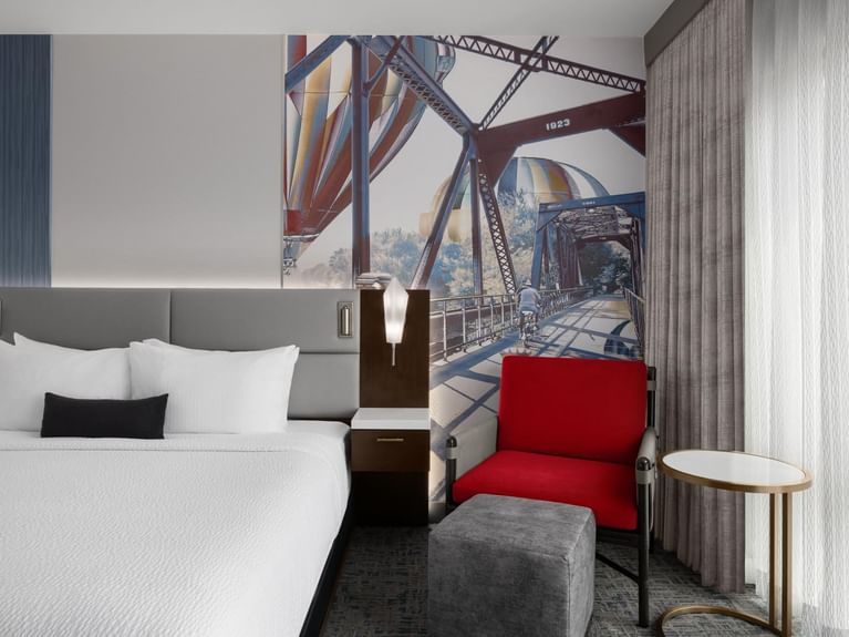 Boutique Double Queen with a cozy queen bed and a large mural of a bridge and hot air balloons at Hotel 43 Boise