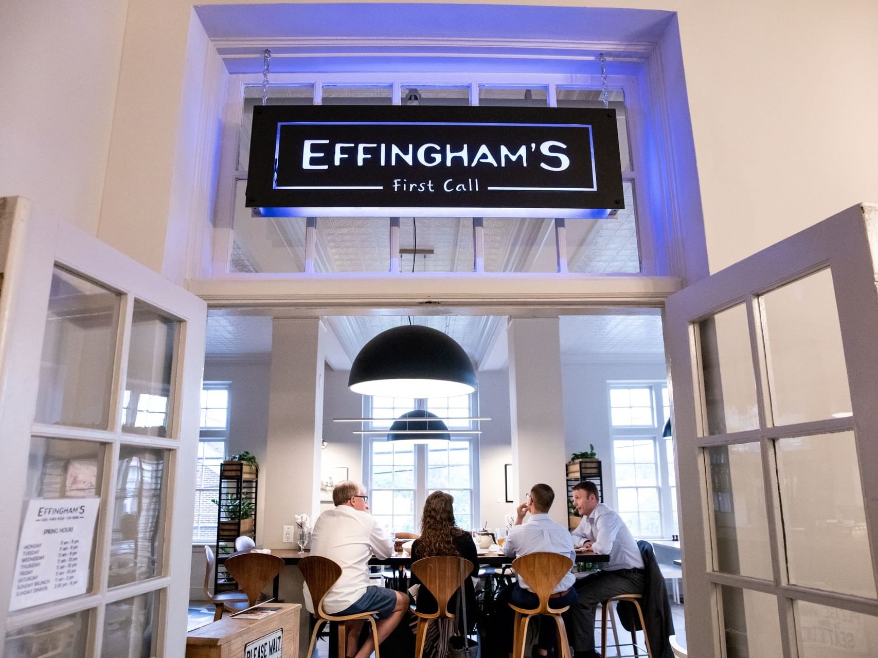 Guests dining near sign featuring Effingham's at Hotel Weyanoke