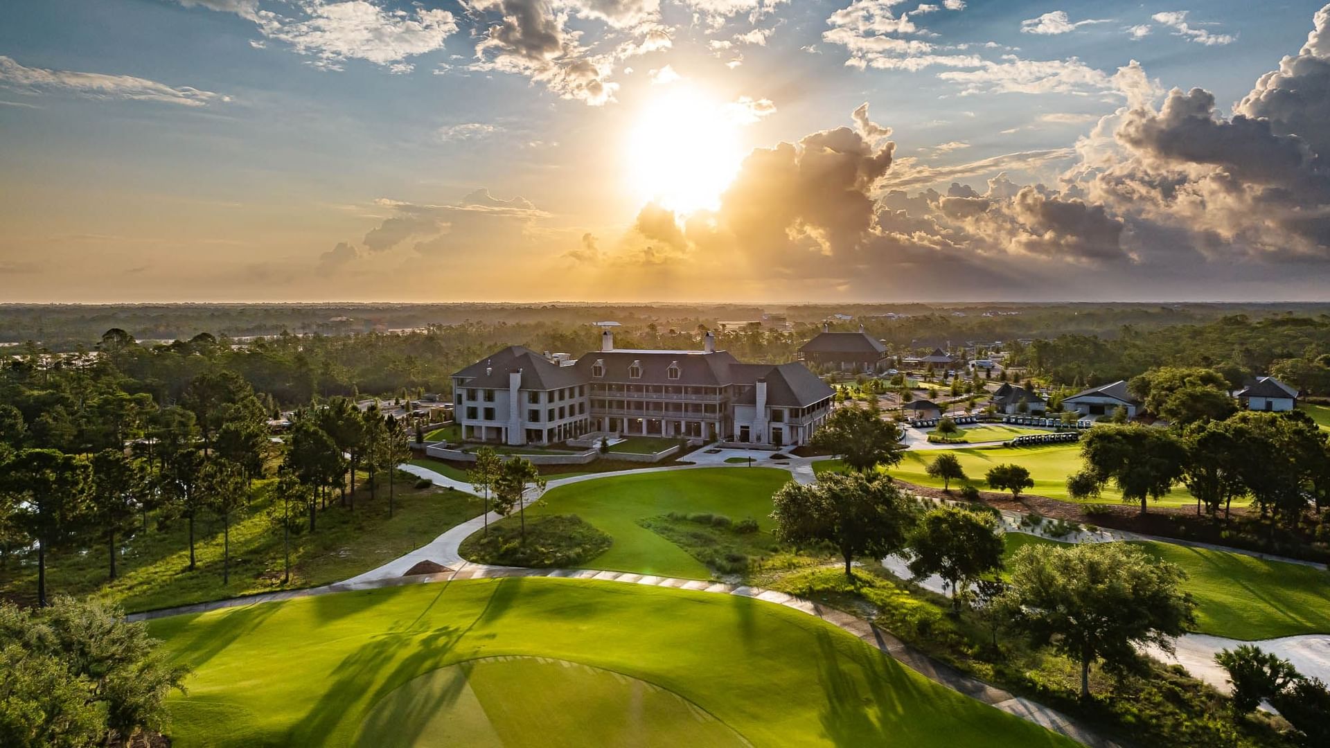 Aerial view of the hotel with lush greenery and golf course nearby at Camp Creek Inn