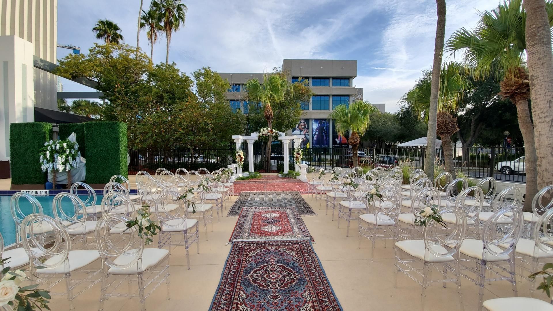 Outdoor wedding chairs set by the pool, with The Barrymore Hotel’s exterior in the background