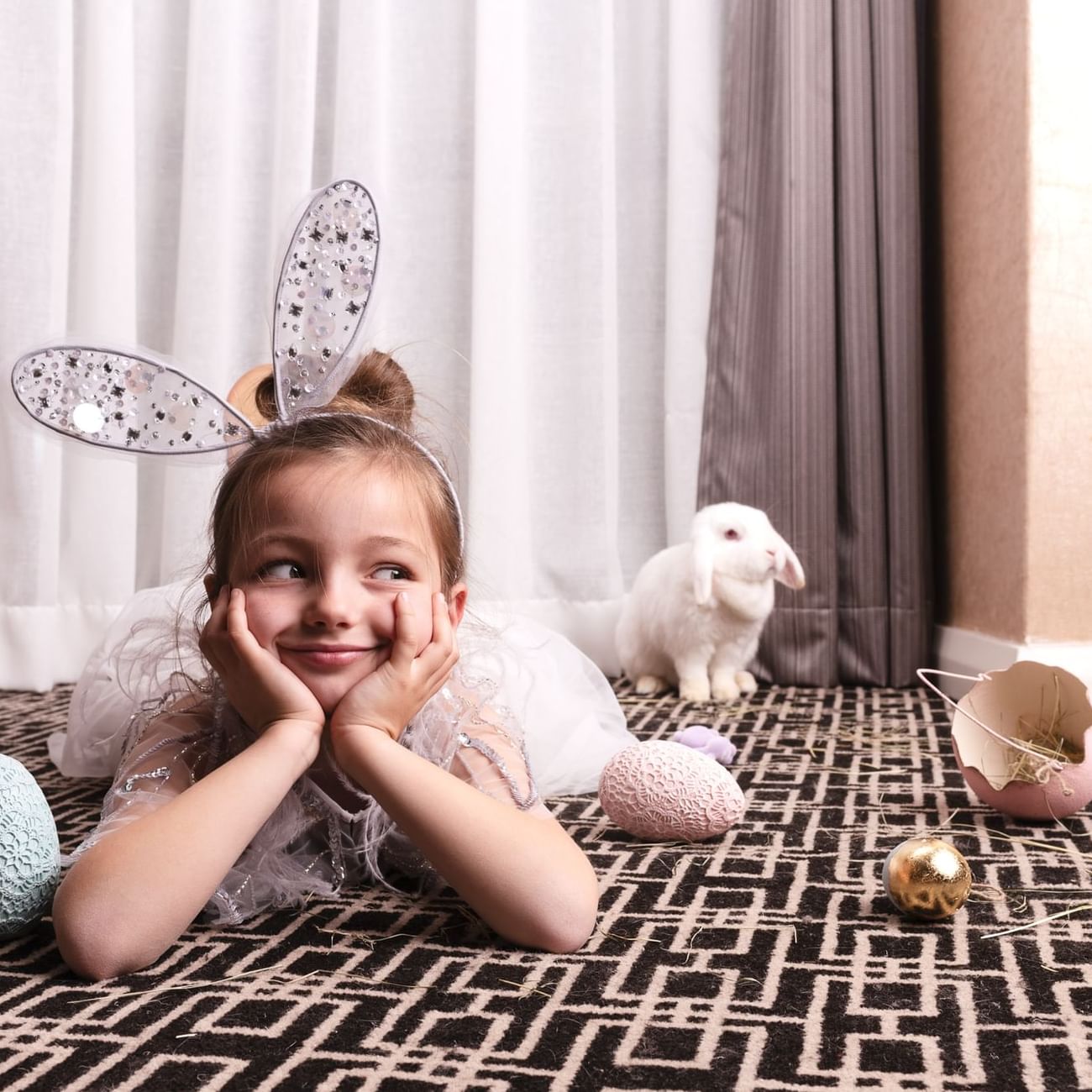 A little girl in a bunny costume is playfully lying on the floor at Sofitel Brisbane Central