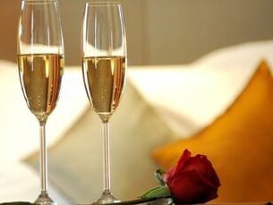 Close-up of 2 champagne glasses and rose at Hotel Parq Central