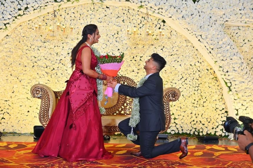 A man kneeling and presenting flowers to a woman at APA Hotel Woodbridge