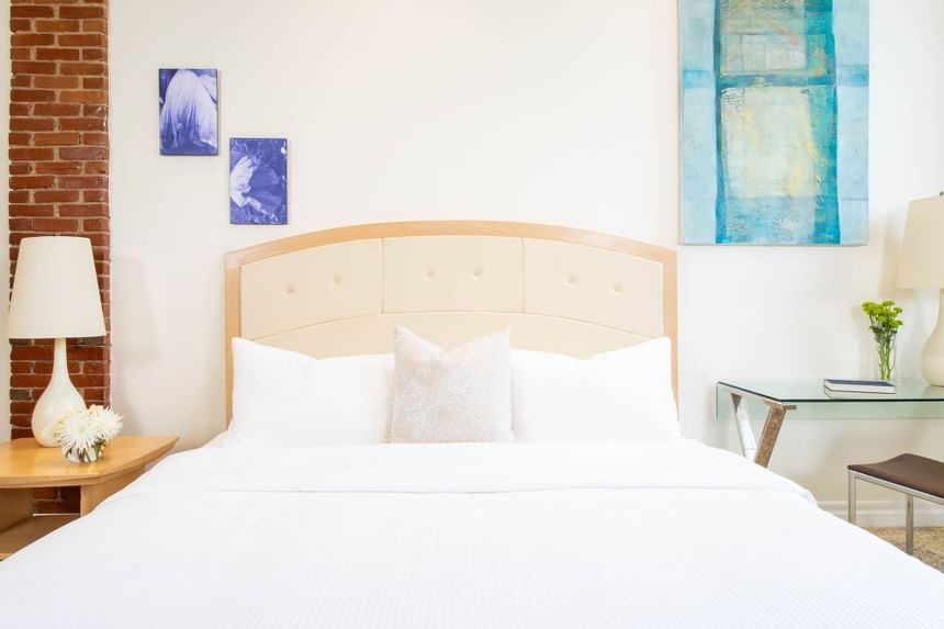 King bed, comfy pillows, work desk with lamp & paintings on the wall in King Premiere Sky at Retro Suites Hotel