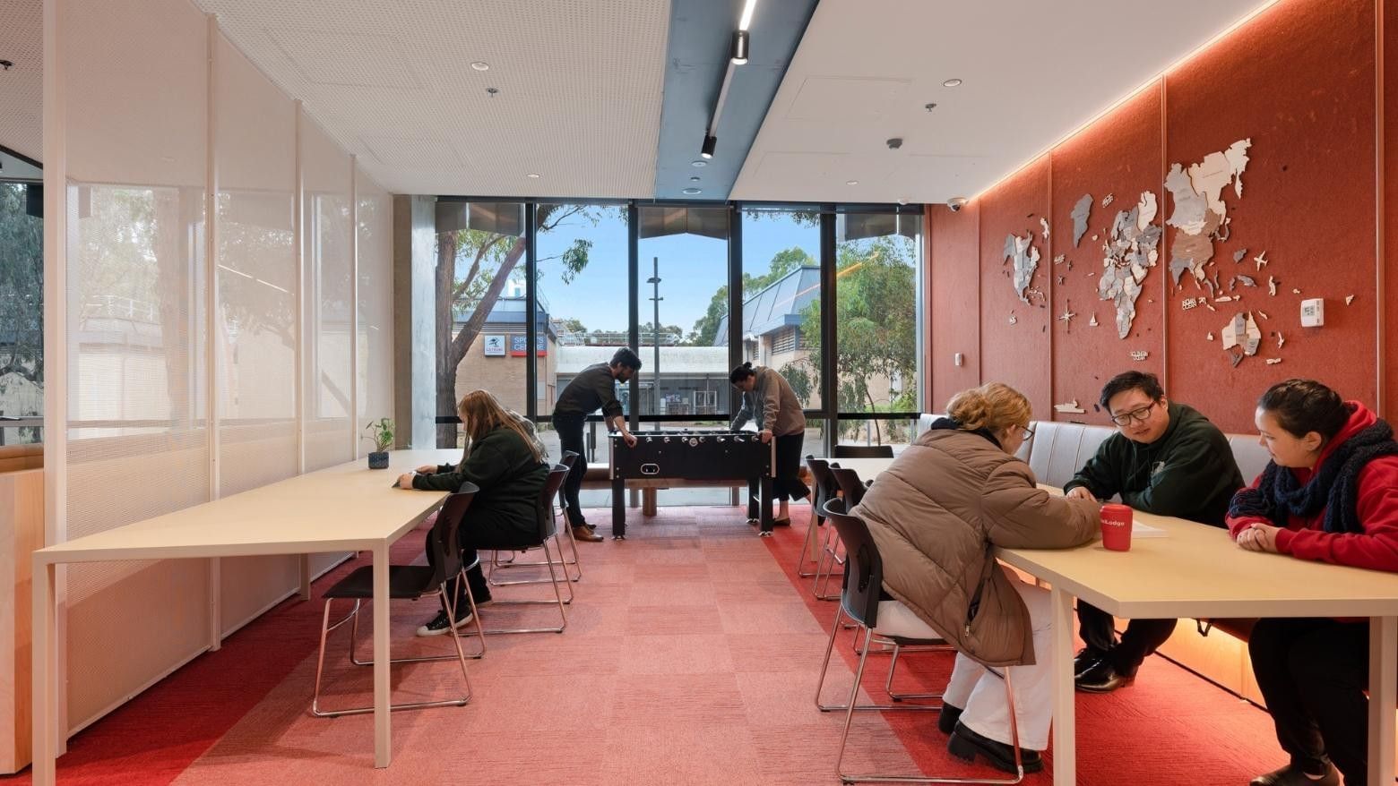 People playing a table game and others working at La Trobe University apartments.