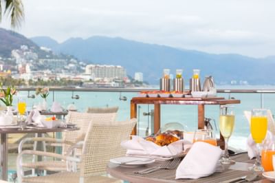 Beachfront dining setup with breakfast and ocean view at Villa Premiere Boutique Hotel & Romantic Getaway