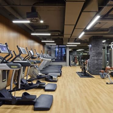 Fitnesscenter mit moderner Ausstattung und Holzböden im Titanic Gendarmenmarkt Berlin.