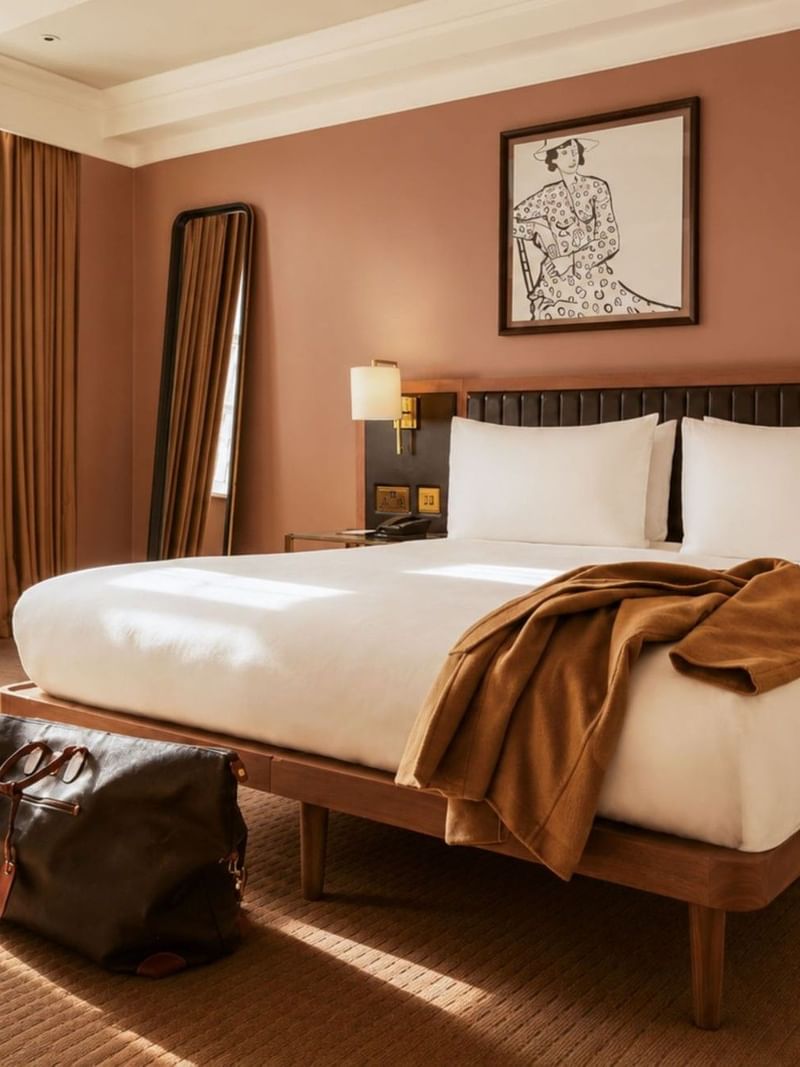 Sunlit Collection Premium Room with king bed, terracotta walls, floor mirror, and artwork at The May Fair Hotel, London.